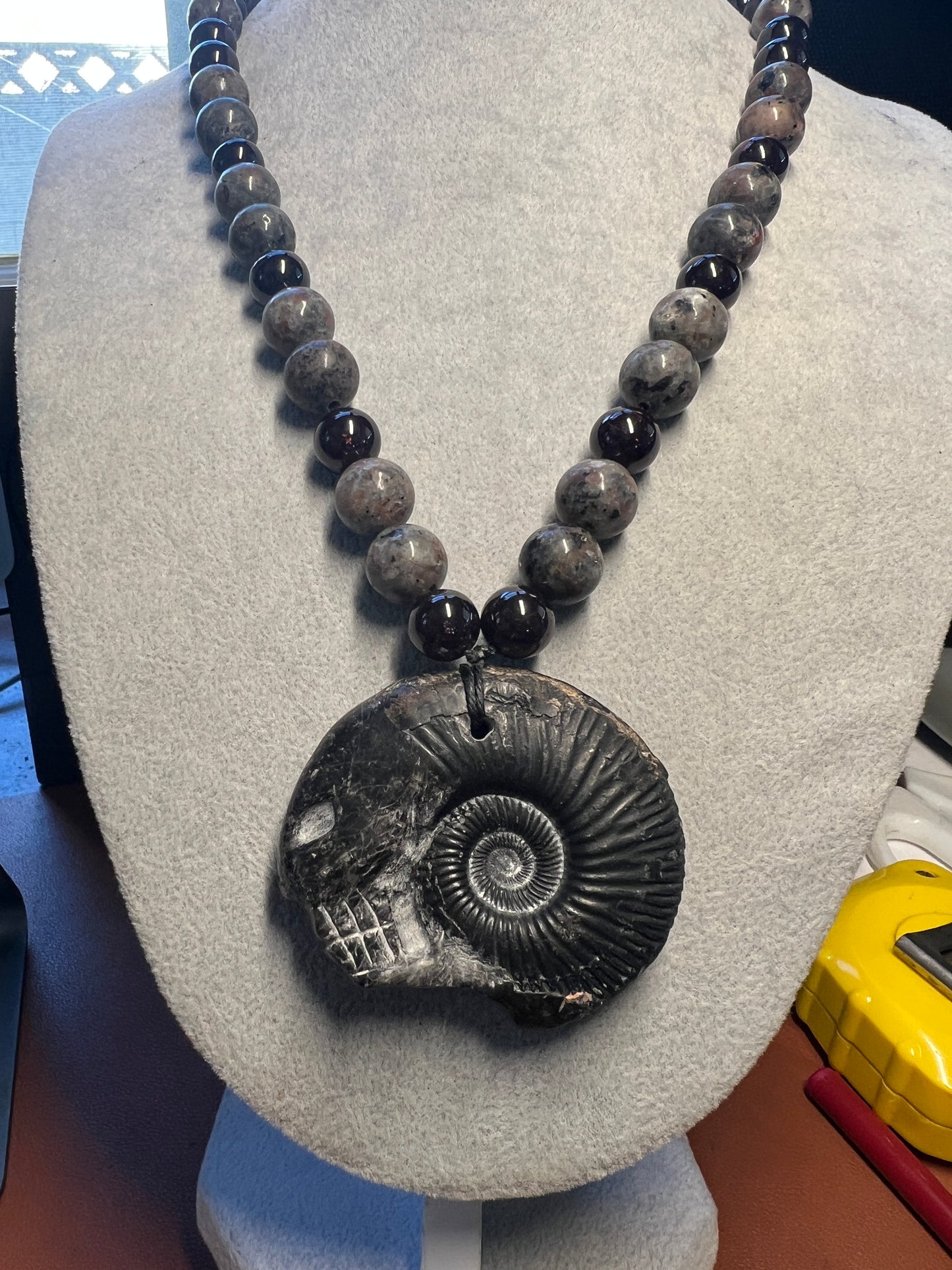 Alien Skull Carved in Ammonite, Necklace translucent garnet spheres yoperlite spheres (#35)